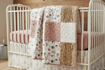 Close-up of dusty rose and gold floral woodland bedding