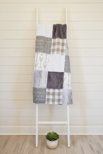 Gray and White Patchwork Blanket on Ladder