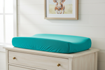 Teal minky changing pad cover on antique dresser with cow art - lifestyle photo